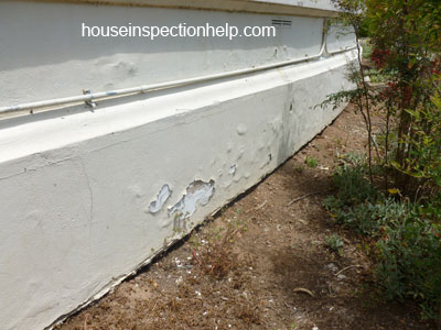 stucco wall finish with water damaged blisters