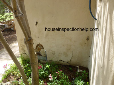 outside picture of badly damaged stucco house wall
