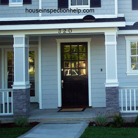 ouside view of closed wood front door on house with siding
